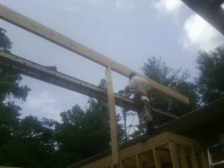 Carpenter setting a ridge beam over a new addition frame — Ice Dam Removal by Roofing Brothers in Kinderhook