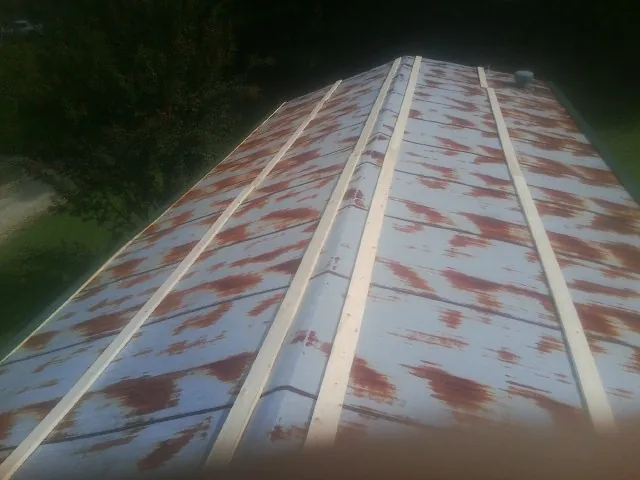 Rusted metal roof panels with new wood purlins before replacement — Storm Damage Roof Repair in Kinderhook by Roofing Brothers