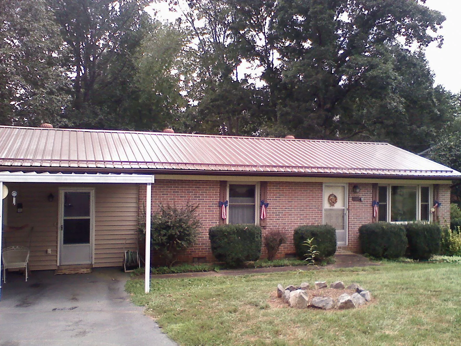Bronze metal roof and carport on a brick ranch home — Roof Repair work by our crew in Kinderhook